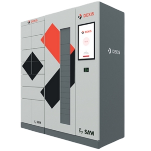 Ein grauer, rechteckiger Automat mit einem digitalen Display in der oberen Hälfte, auf dem das Logo "DEXIS" zu sehen ist. Darunter befinden sich vier Schubladen. Auf der unteren Seite des Automaten steht "By SAM"