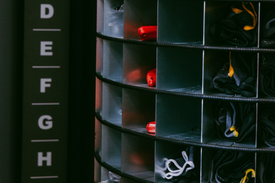 Der DEXIS Spiralautomat von innen. Man sieht einzelne verschieden große Fächer mit Produkten gefüllt wie rote Tapetenmesser und Handschuhe